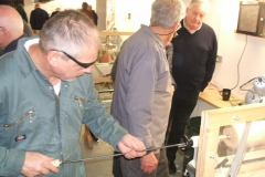 Here Graham Charge is using the long hole boring tool, being observed by some of the members.