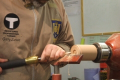 Gary starts to shape the bottom of the spinning top.