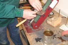 A closer view of how David holds the tool as it's being sharpened, note the position of the tool guide above the belt.