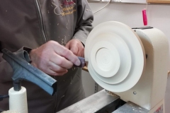 Douglas has shaped the base and can be seen sanding for the finish.
