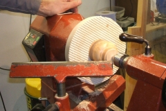 To clean up the bottom and get rid of any chuck marks, Mark has used a piece of router mat fixed to a disc and held the cup between centres using the tailstock, some very minor sanding would be required after cleaning up the base.
