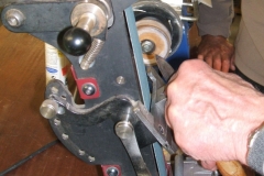 Errol Levings about to sharpen a parting tool with a belted machine.